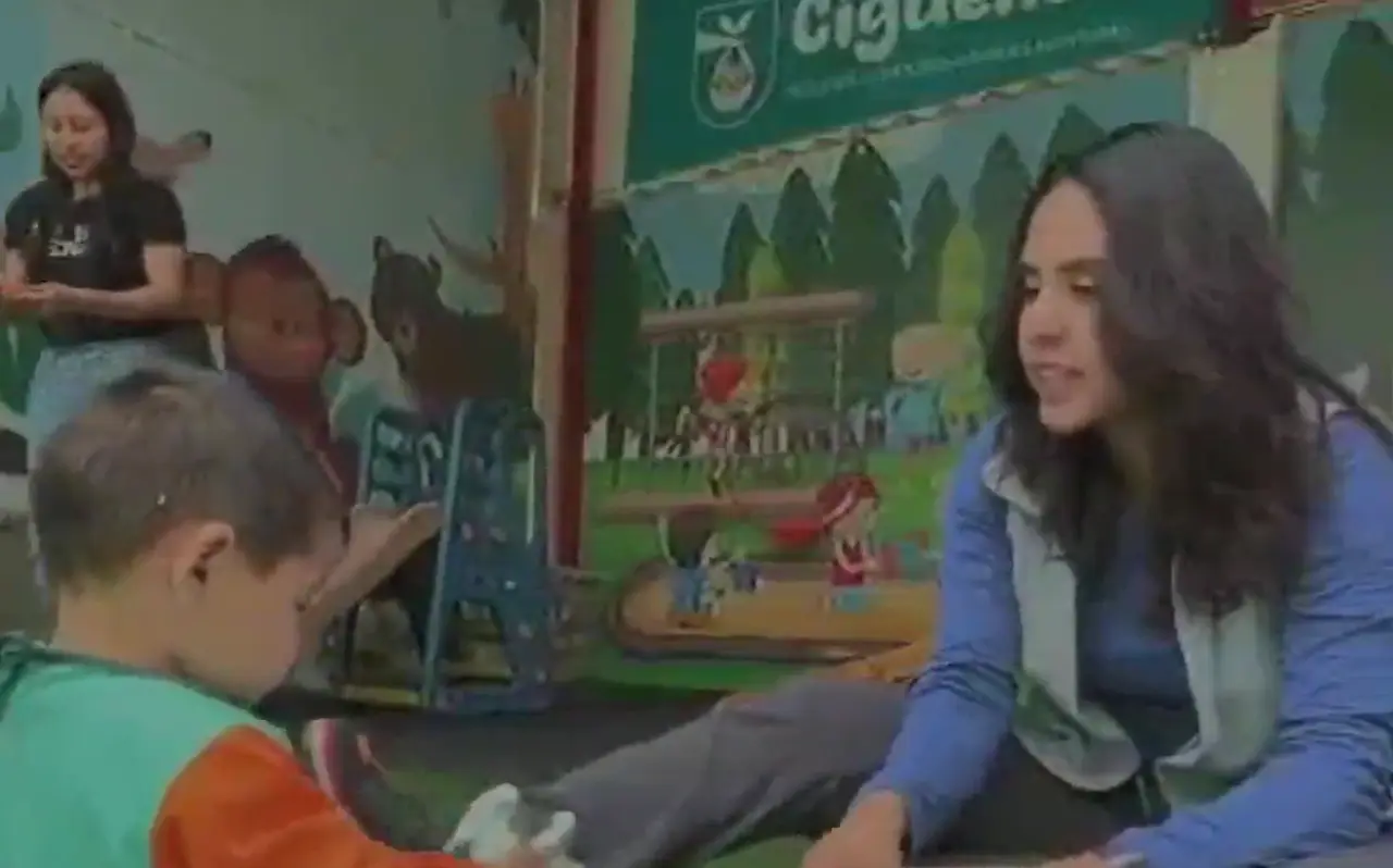 Educadora y niño en una actividad sobre el césped