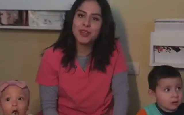 Educadora de Cigüeñas cuidando a una bebé y a un niño